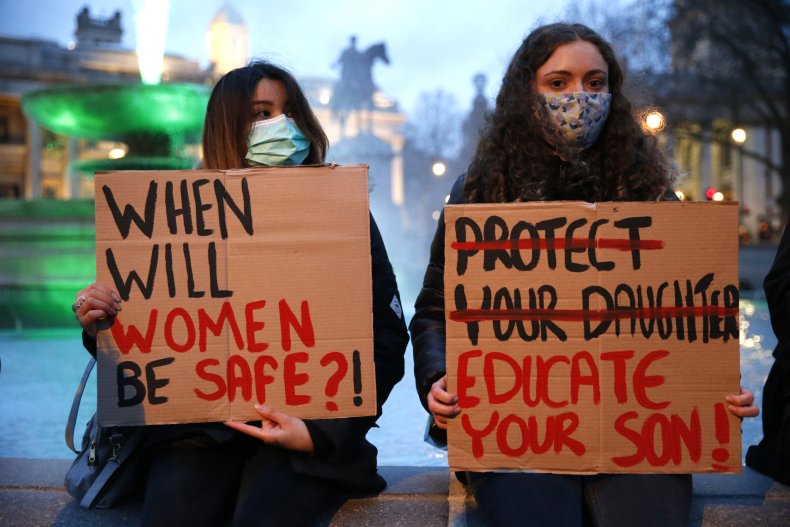 Members of the public hold up signs