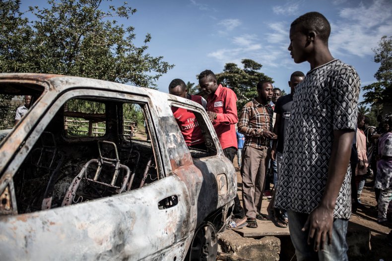 Congolese men look on at a car 