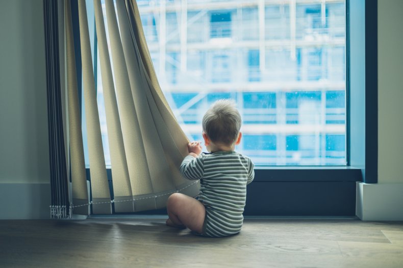 Child playing with window shade