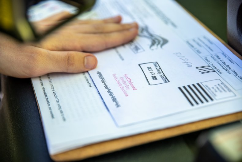 A poll worker stamps a voters ballot