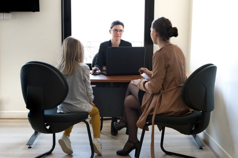 A woman and daughter in school meeting.