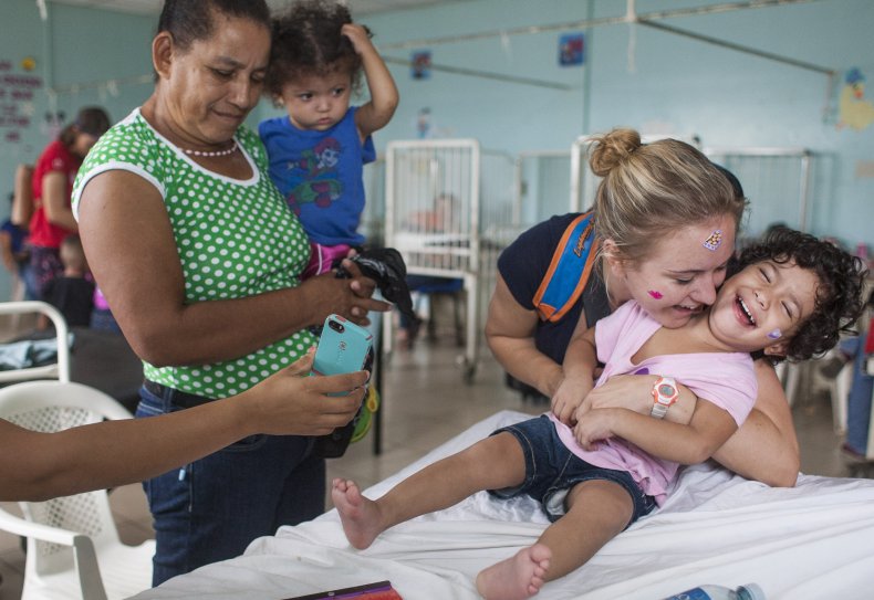 A girl plays with a volunteer nurse