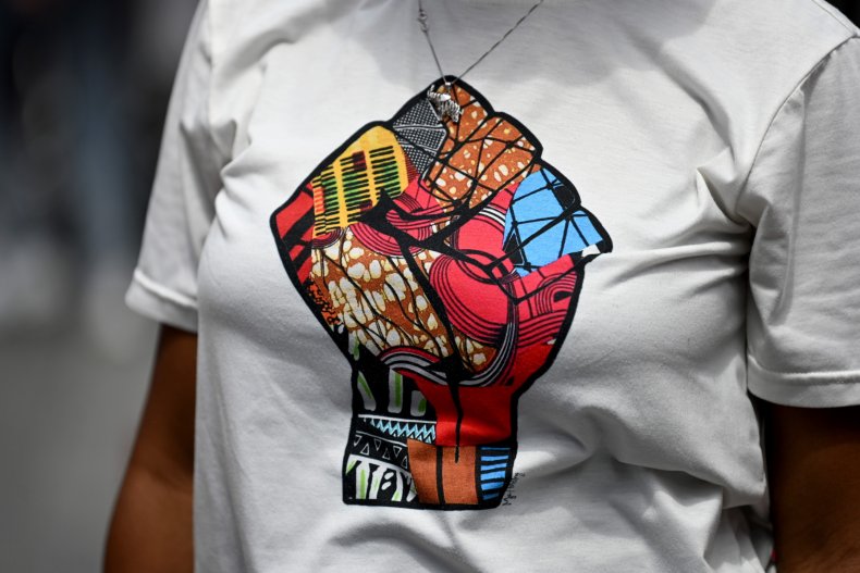 A woman wears shirt with raised fist