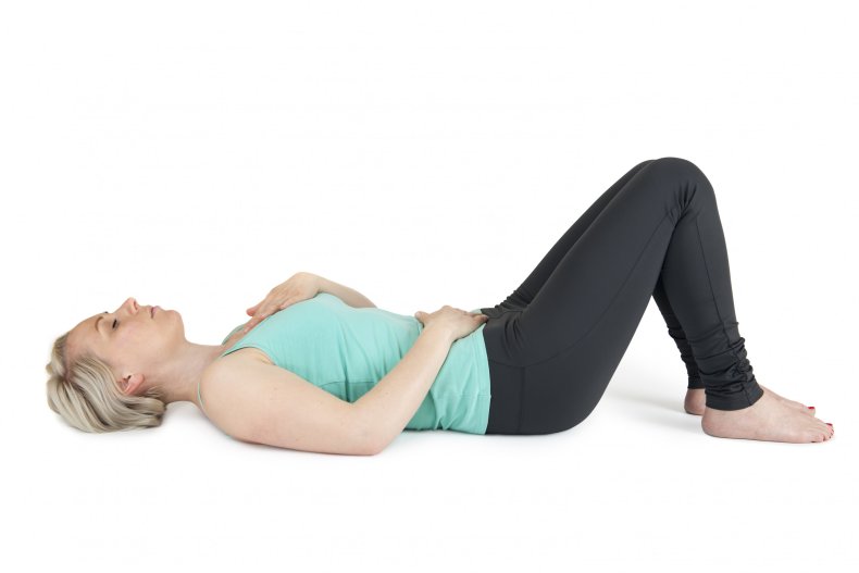 A woman laying down, knees bent up.