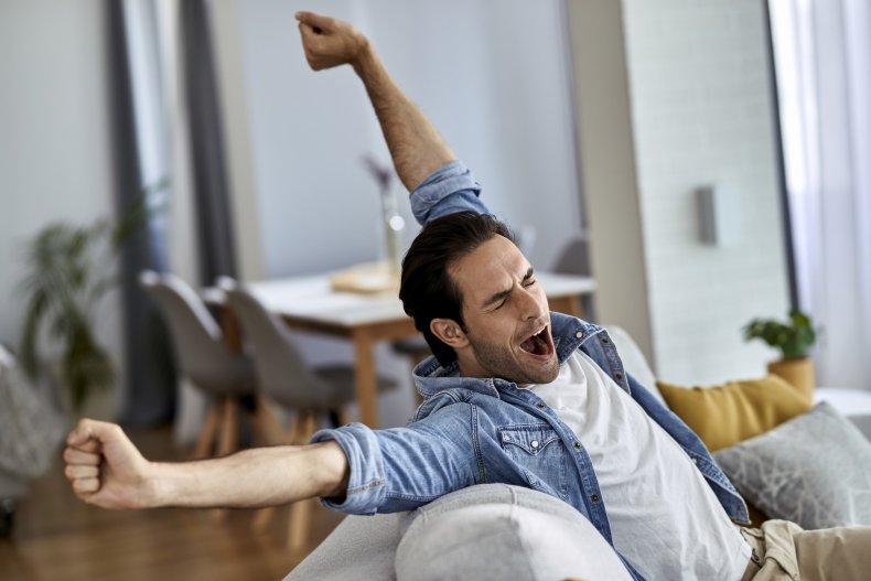 A man yawning with outstretched arms.