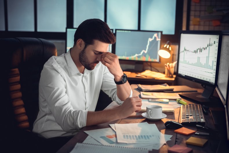 A man stressed, sitting at a desk.