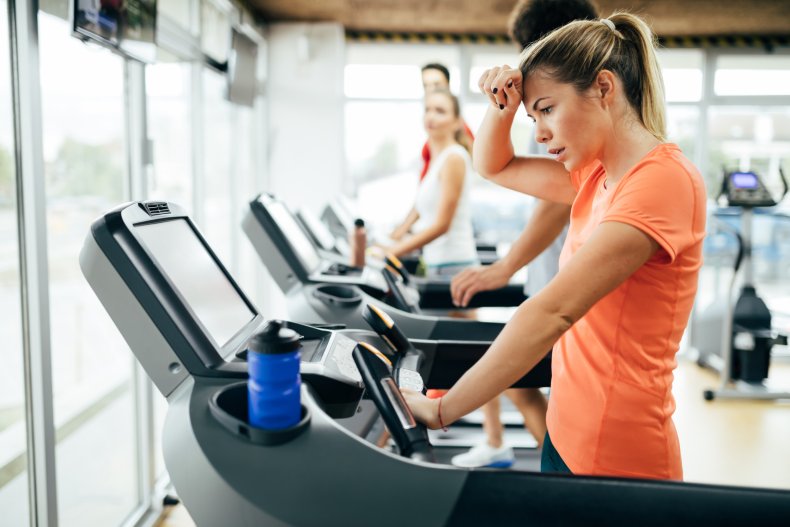 A woman looking at a treadmill dashboard.