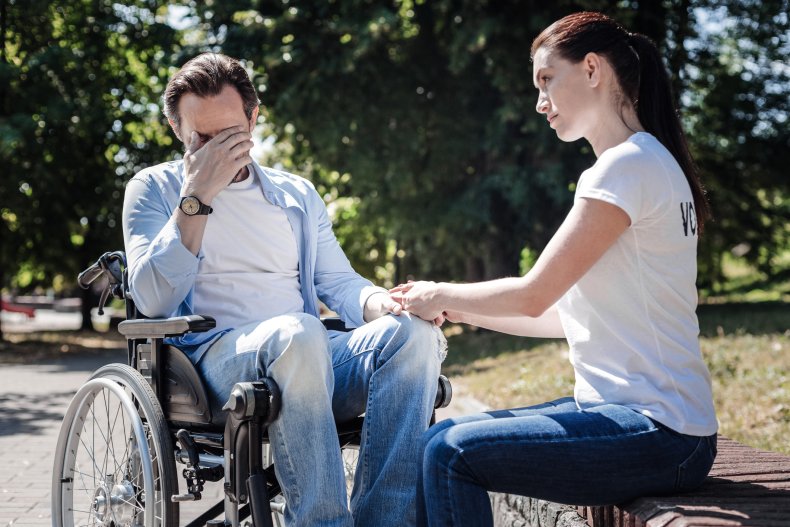 A man in a wheelchair looking upset.