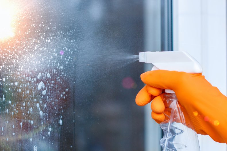 orker cleans the Windows with spray in