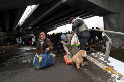 Ukrainians prepare to cross a destroyed bridge