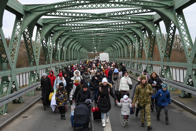 Ukrainian refugees walk a bridge 