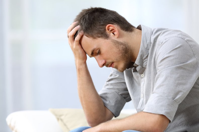 An anxious man with hand on head.
