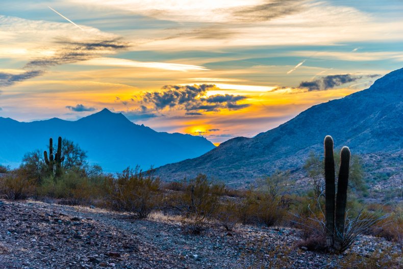 The sun sets behind Estrella Mountain