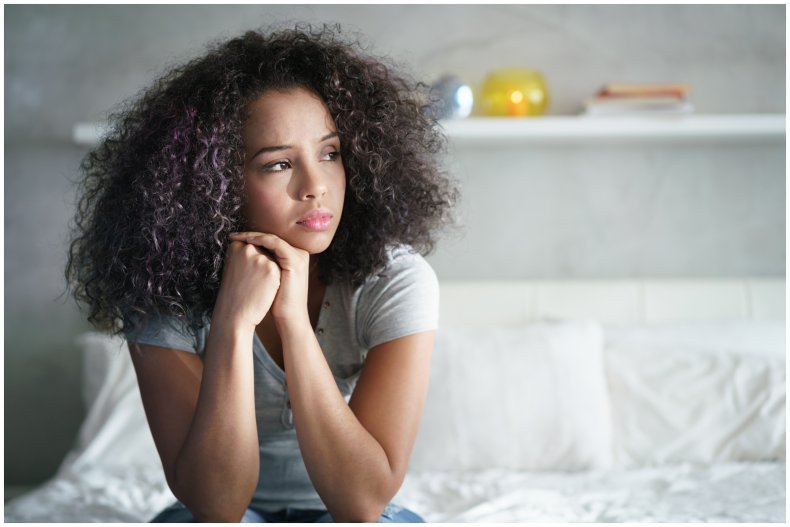Stock image of woman sitting on bed