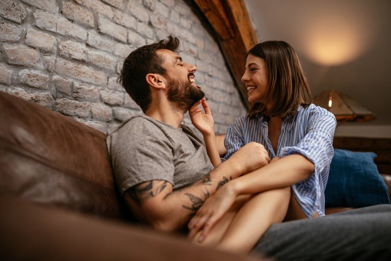 An affectionate couple sitting on a sofa.