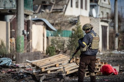 Ukrainian soldier amid wreckage of houses