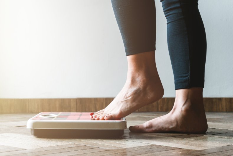 Female checking kilogrammes getting on the scale 