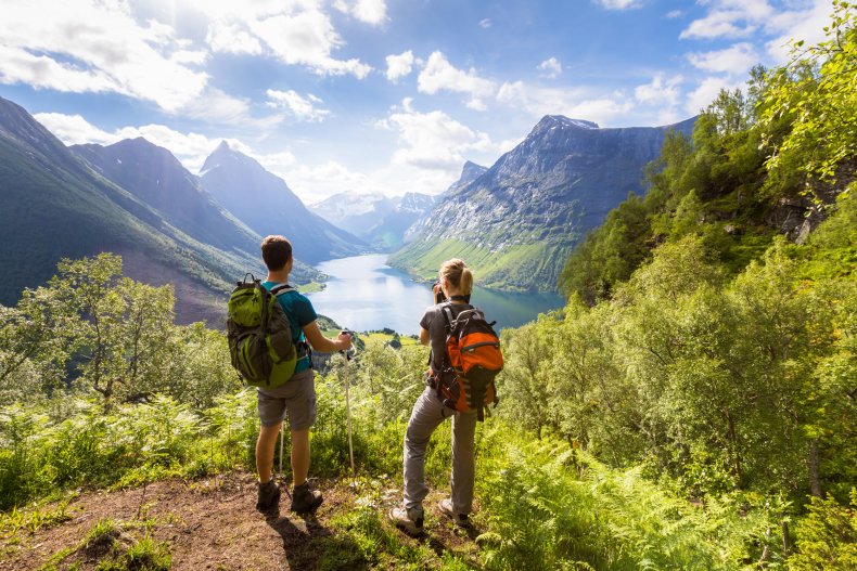 Two hikers looking out over mountains. 