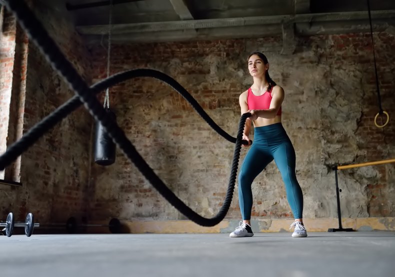 A woman doing rope lifting exercises indoors.