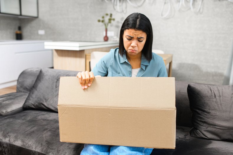A woman looking disappointed at a box.