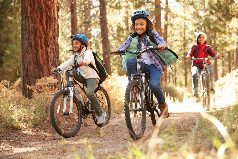 Children cycling through a forest.