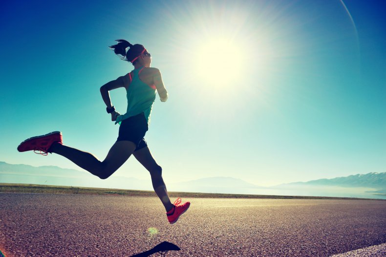 A woman running along a seaside trail. 