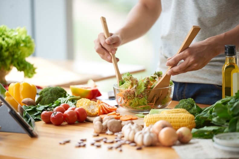 A person preparing a salad in kitchen.