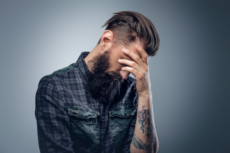 Tattooed hipster man looking frustrated 