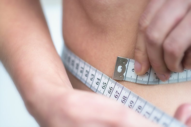 Woman measures very thin waist with measuring 