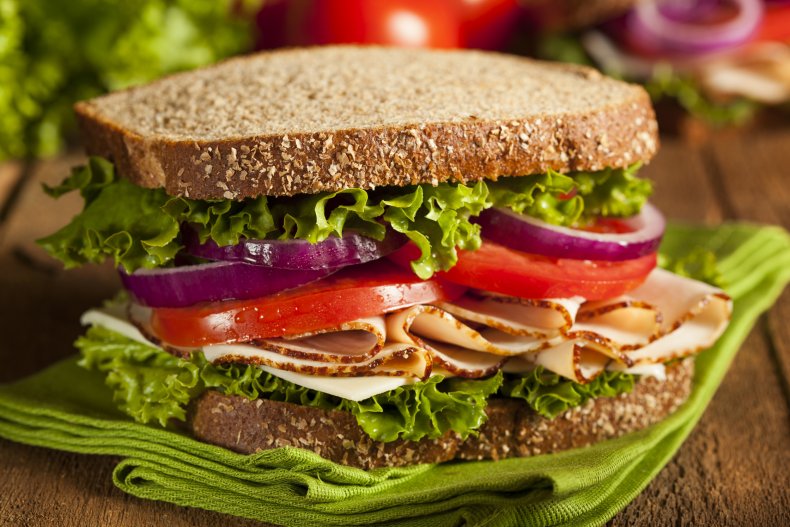 A turkey sandwich with wholegrain bread, vegetables.