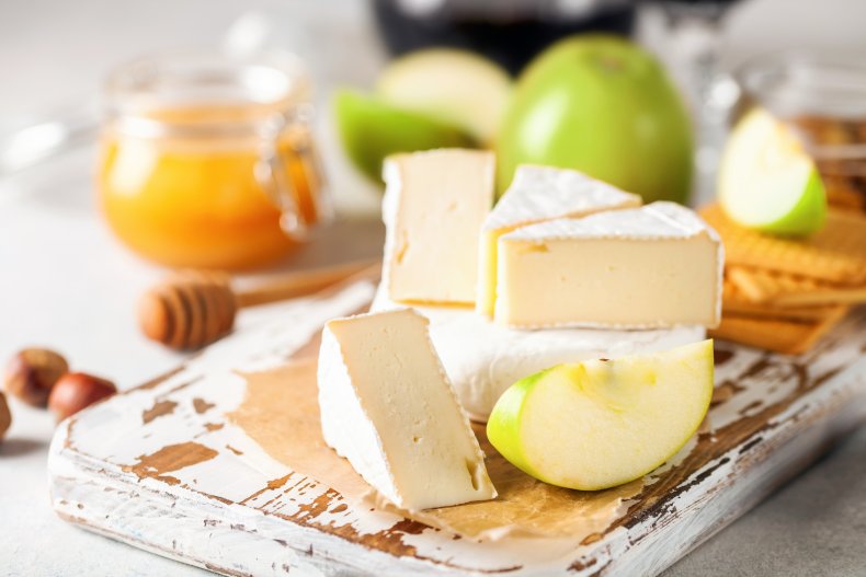 Cheese, apple, crackers on a wooden board.