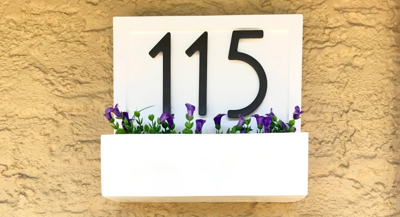 A flower box plant stand on wall.