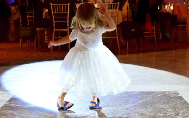 Une petite fille danse à un mariage.