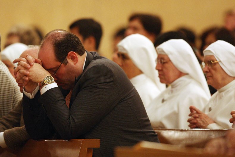 People pray during the celebration of the