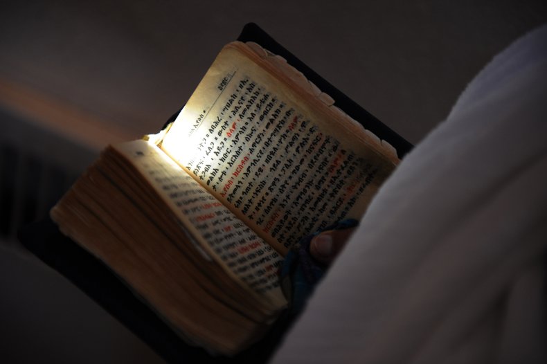 A parishioner reads a prayer book 