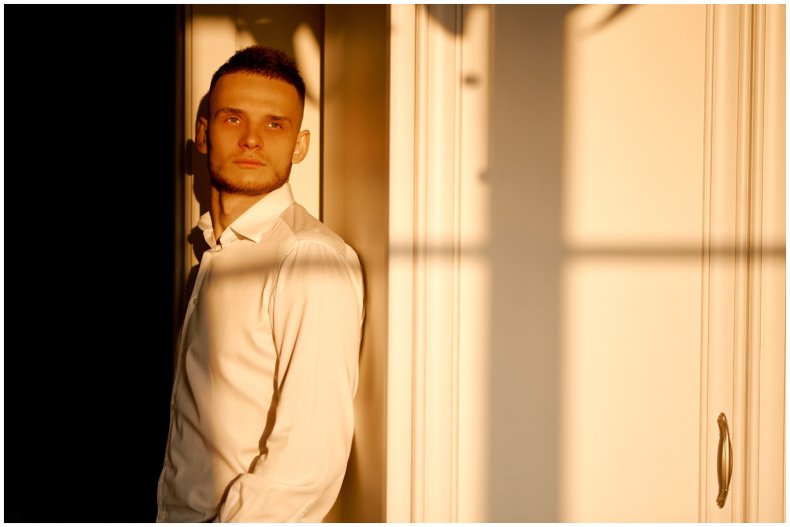 Stock image of man looking out window