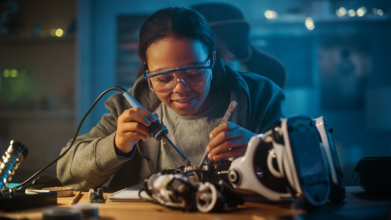 A woman working on wires, circuit boards.