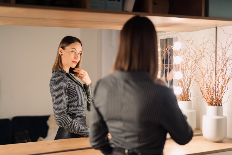 A woman looking at herself in mirror.
