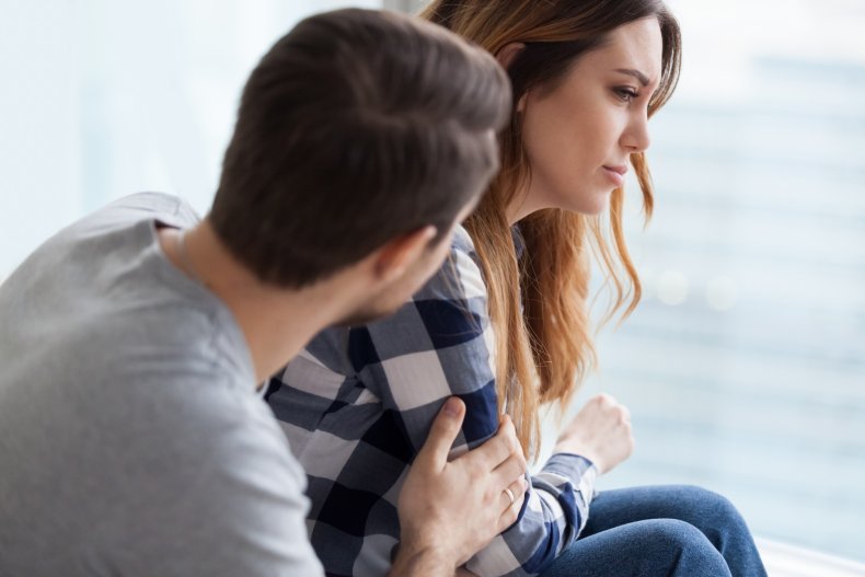 A man comforting a woman looking distraught.