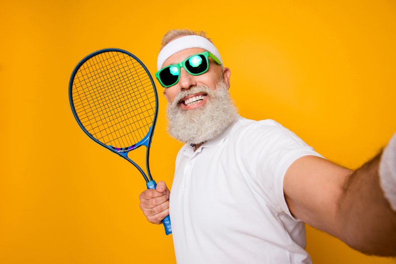 Older man wearing tennis clothes holding racket