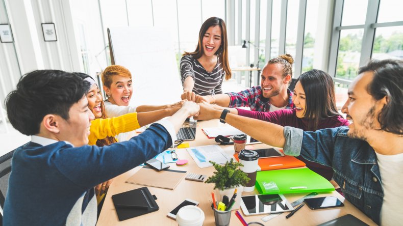 Office workers fist-bumping each other.