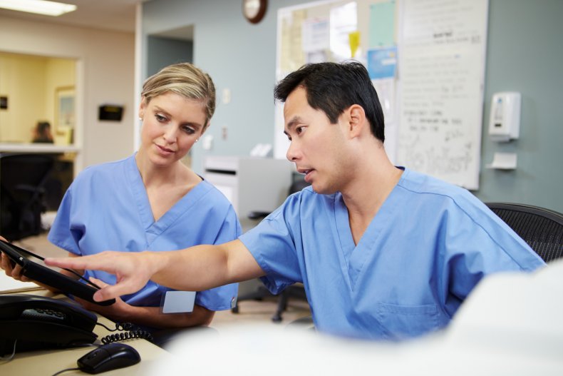 Nurses looking at computer tablet at hospital.