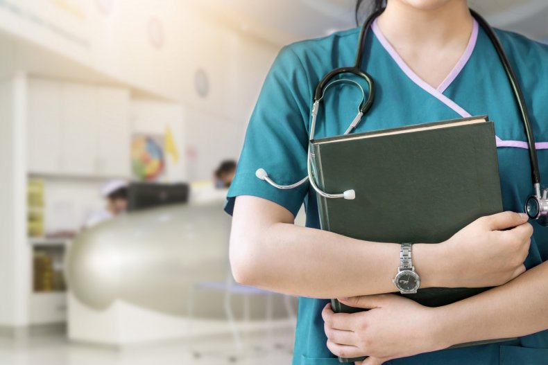 A closeup of a nurse holding book.