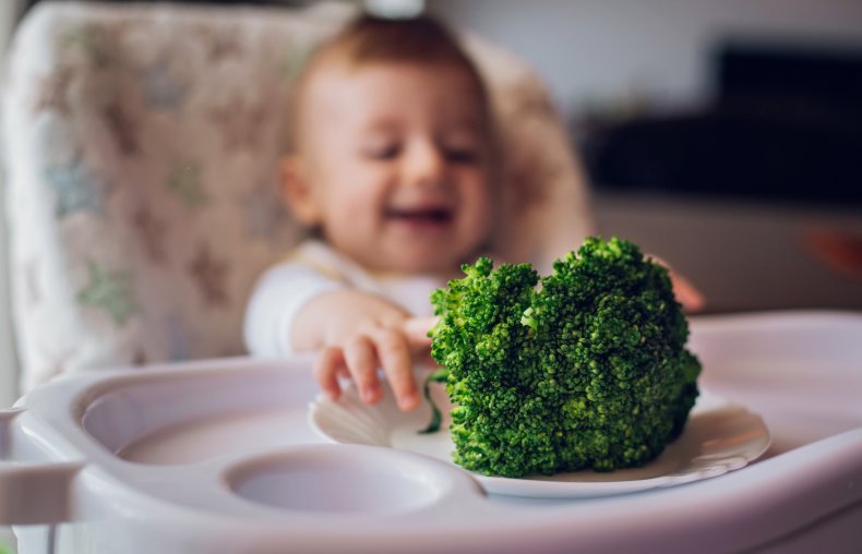 Baby eating broccoli