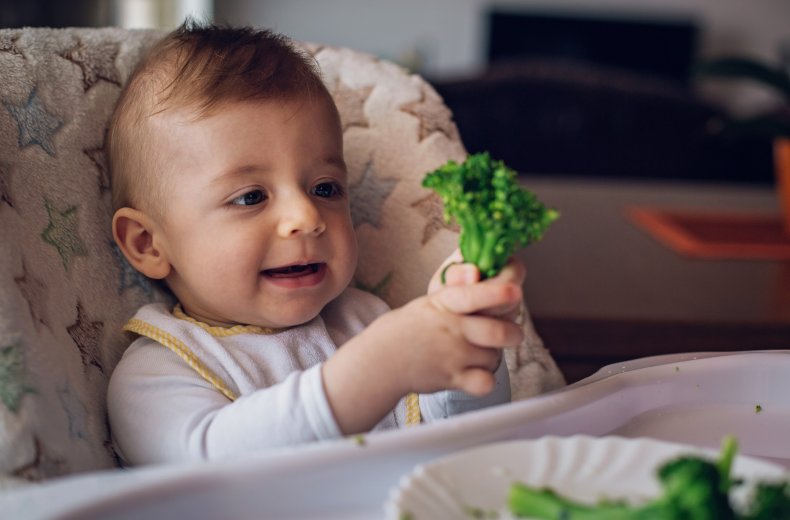 Baby eating broccoli