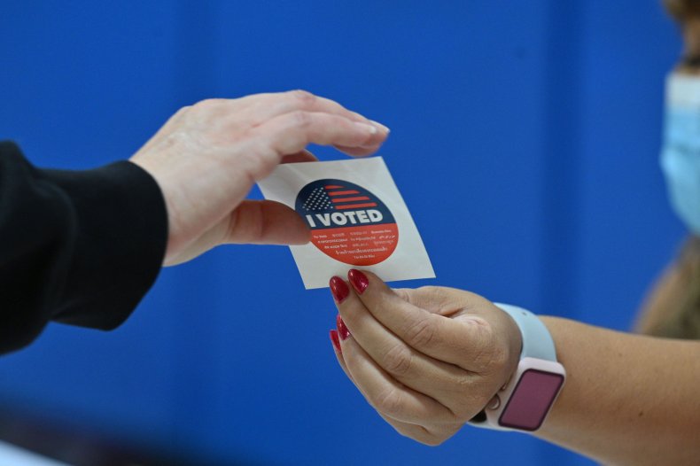 A voter takes an "I Voted" sticker