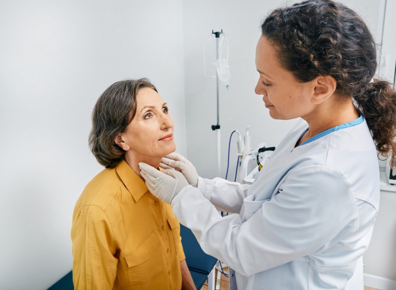 A doctor examining a woman's thyroid glands.