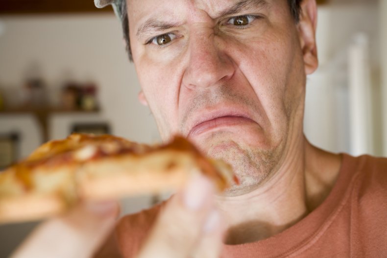 Dissatisfied man looking at pizza