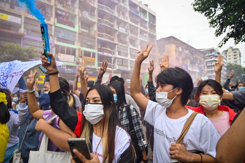 Protesters make the three-fingered salute