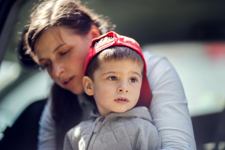 Mother comforts nervous-looking child